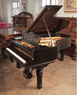 Reconditioned, 1900, Steinway Model B grand piano with a satin, black case and fluted, barrel legs. Piano has an eighty-eight note keyboard and a three-pedal lyre