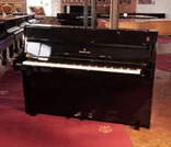 Reconditioned, 1960, Steinway Model F upright piano for sale with a black case and brass fittings. Piano has an eighty-eight note keyboard and two pedals. 